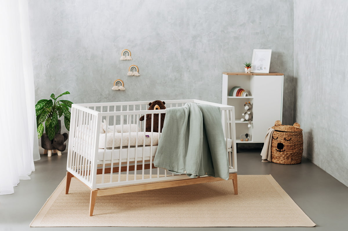 Eingerichtetes Kinderzimmer mit Babybett und Kommode