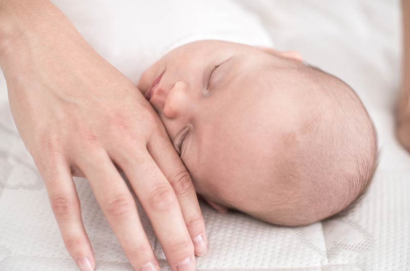 Schlafendes Baby welches gestreichelt wird Schlafendes Baby welches gestreichelt wird