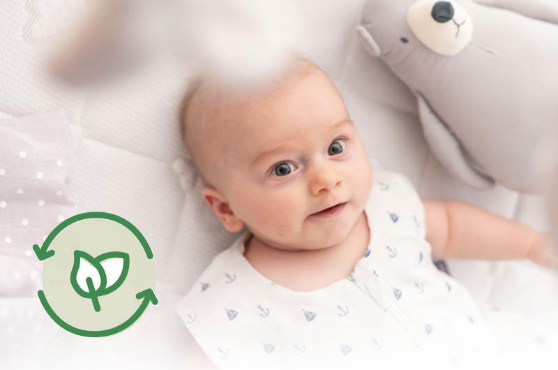 Baby im Sommerschlafsack im Babybett Baby im Sommerschlafsack im Babybett