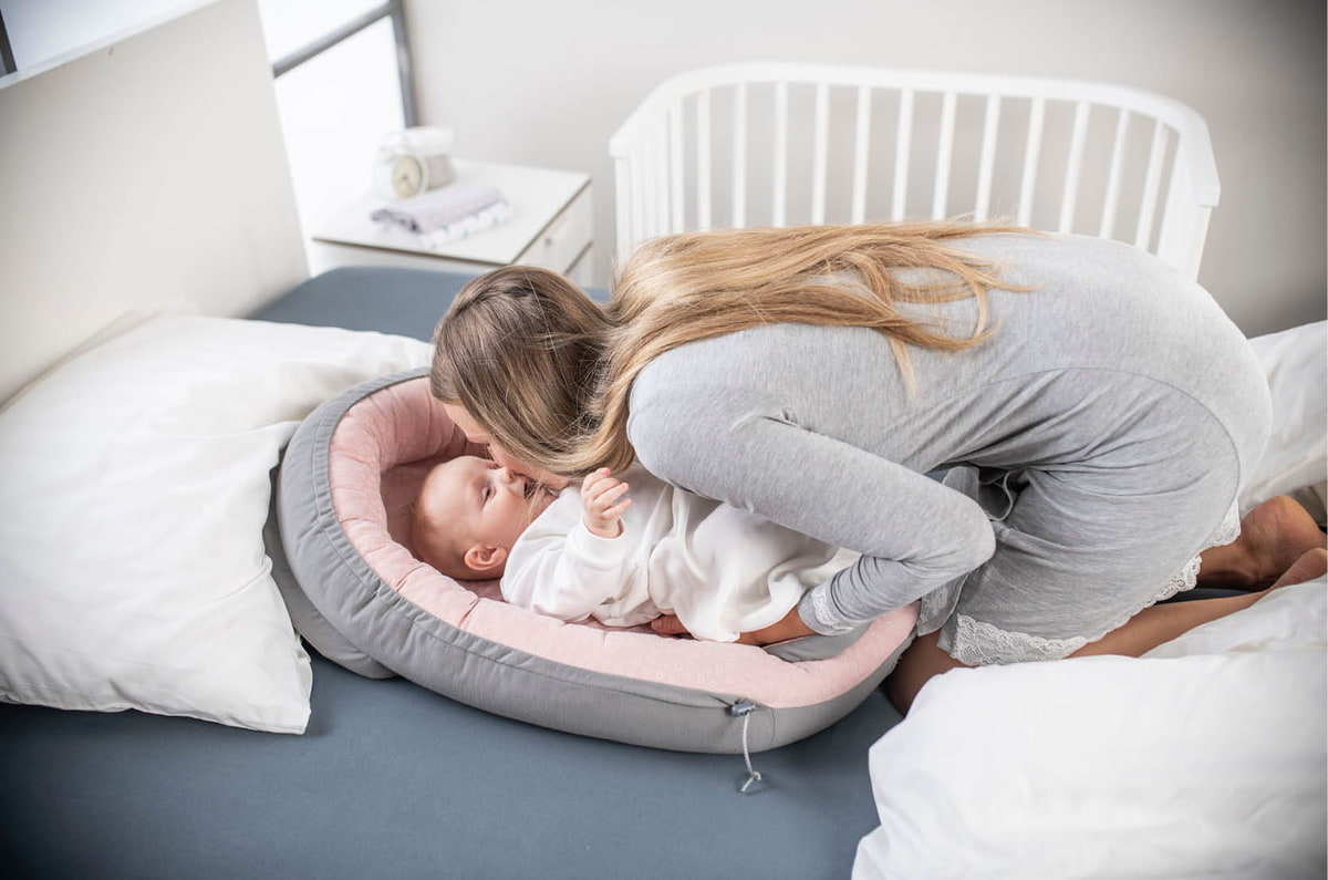 Baby mit Mama im Bett