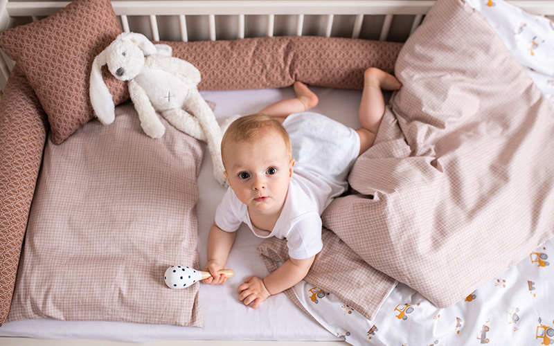Baby im Gitterbett mit Bettwäsche Kleine Farm und Bettschlange Fische braun Baby im Gitterbett mit Bettwäsche Kleine Farm und Bettschlange Fische braun