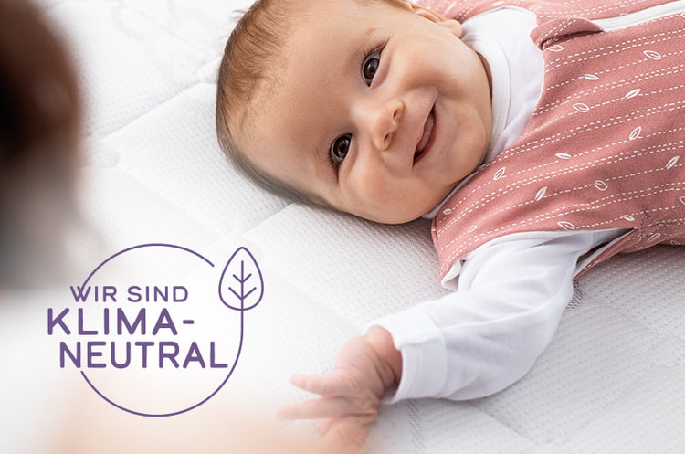 nachhaltige Babyausstattung Baby auf nachhaltiger Babymatratze in einem nach GOTS zertifizierten Schlafsack