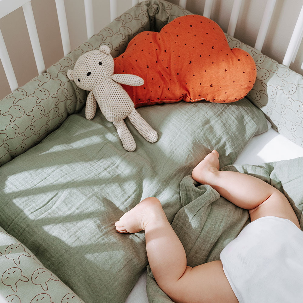 Babyfüße im Bett mit Musselin Bettwäsche Babyfüße im Bett mit Musselin Bettwäsche