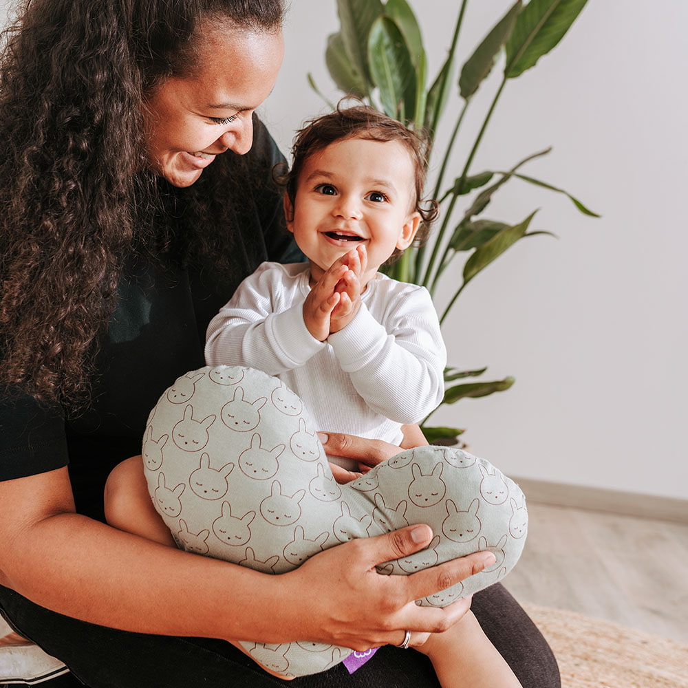 Baby kuschelt mit Mama und Kuschelkissen Baby kuschelt mit Mama und Kuschelkissen