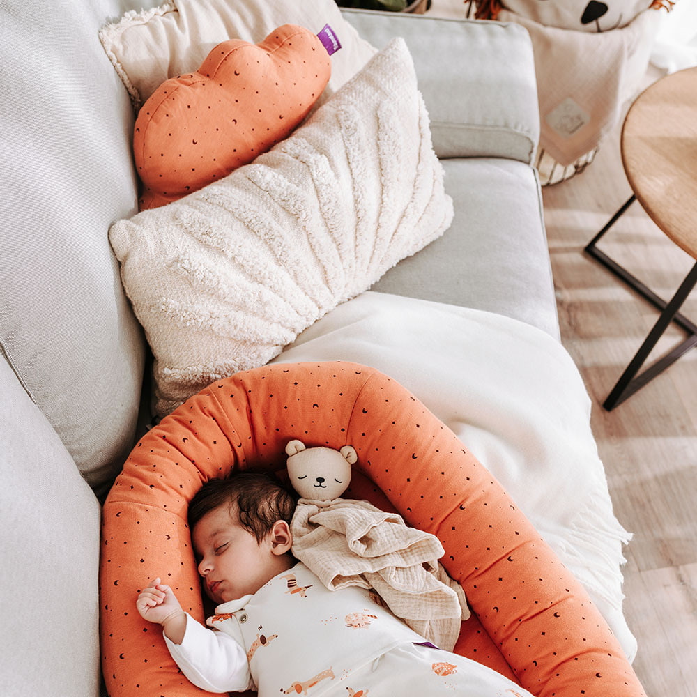 Baby schlafend im Home Nest auf der Couch