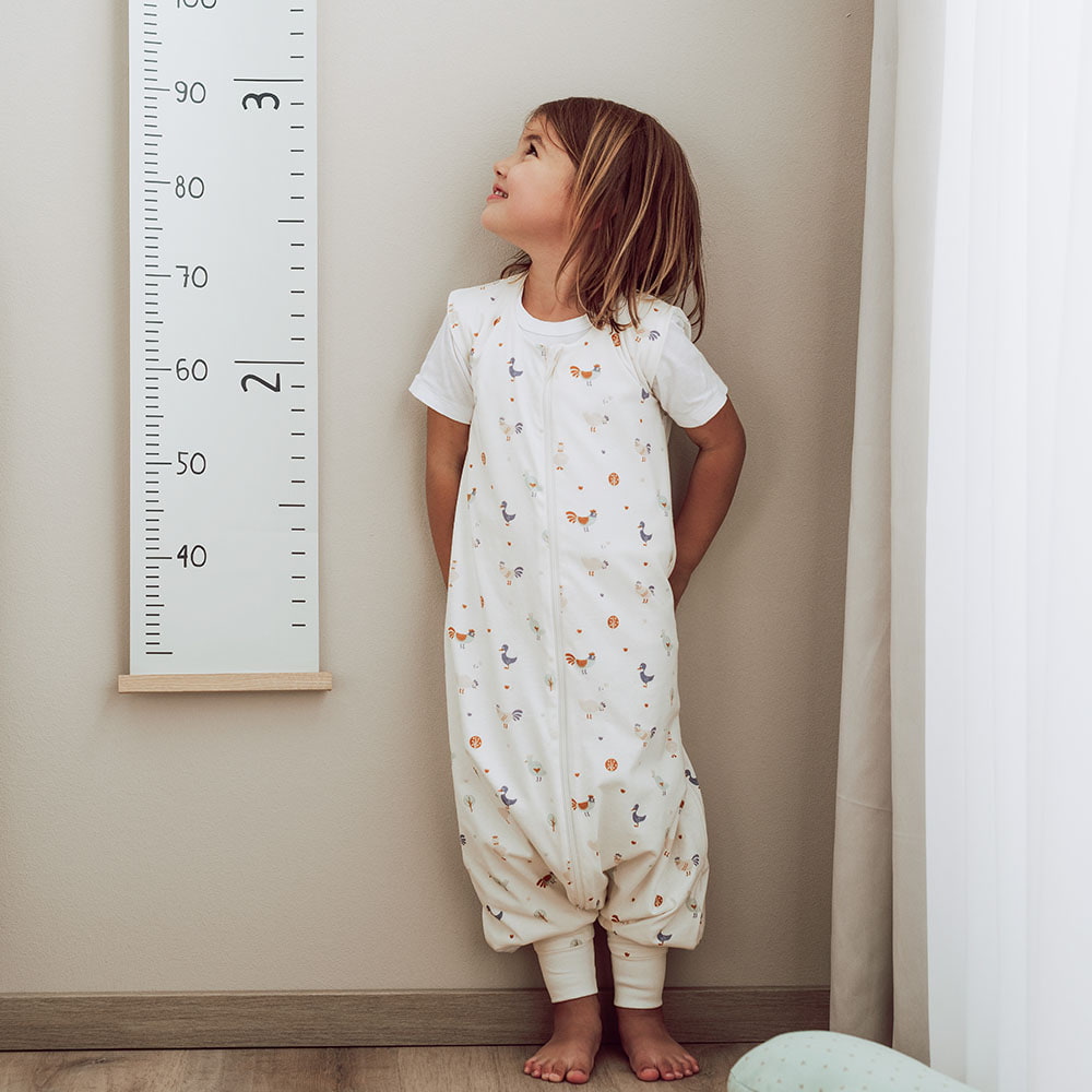 Kind in Schlafsack mit Füßen in Kinderzimmer Kinderschlafsack mit Füßen mit Beinen in Kinderzimmer