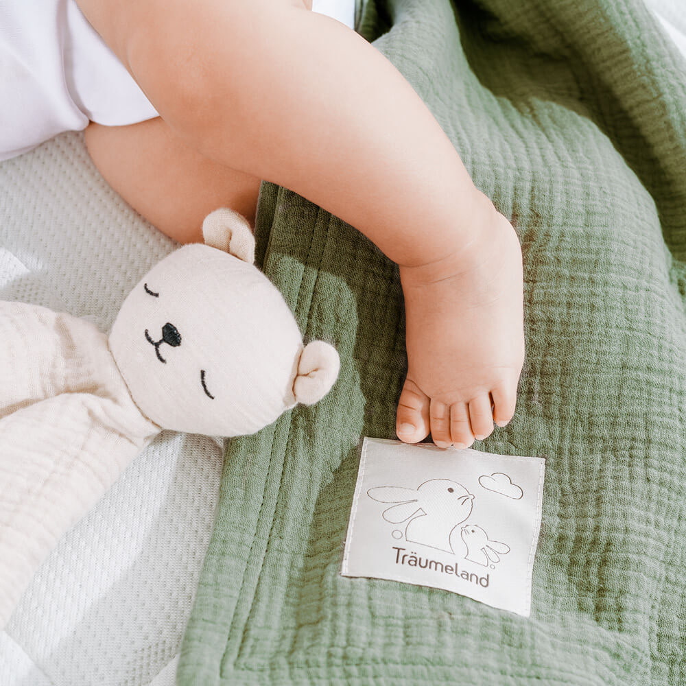 Babyfuß auf kuscheliger Musselindecke