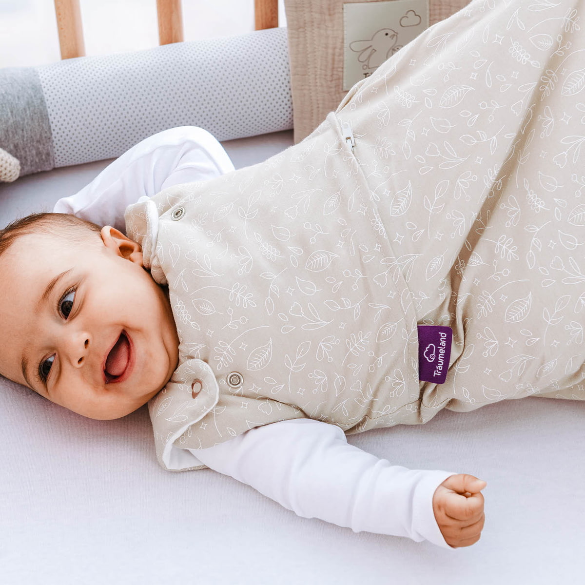 Baby mit Kuschelkissen und Schlafsack