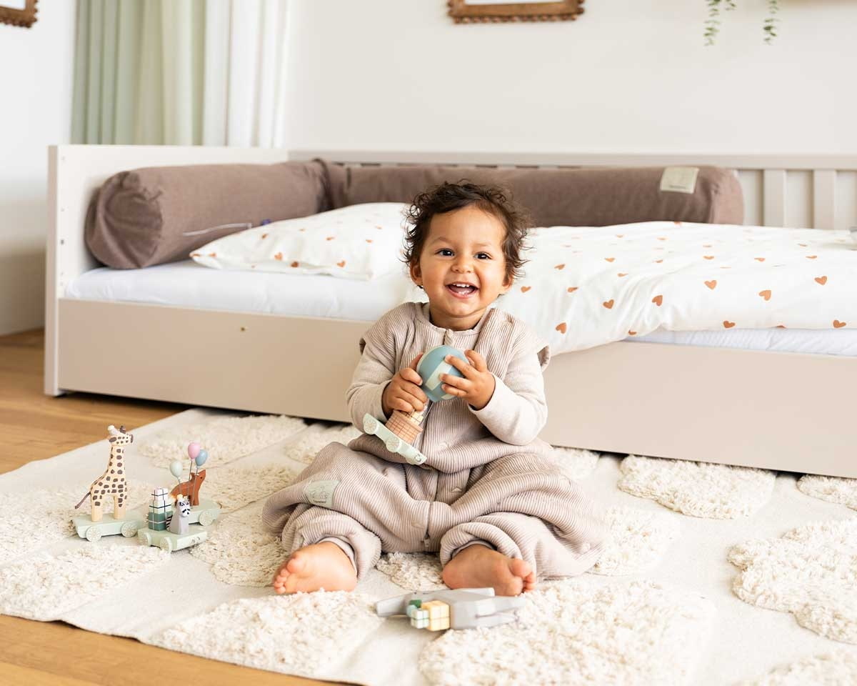 Spielendes Baby mit Schlafsack mit Füßen schlafsack-mit-füßen-traeumeland-baby-aktiv-spielt-schlafsack